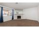 Open living room with neutral carpet, fireplace, bright window and blue curtains at 1333 Pinto Rock Ln # 202, Las Vegas, NV 89128