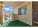 Private condo patio with secure gate, artificial turf, and view of parking area at 1333 Pinto Rock Ln # 202, Las Vegas, NV 89128