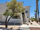 Condo with stairs, showcasing the building's facade and nearby landscaping on a clear day at 1904 Las Palmas Ln # 101, Laughlin, NV 89029