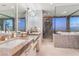 Bright bathroom featuring double sinks, and a glass shower with tub overlooking city views at 200 W Sahara Ave # 4101, Las Vegas, NV 89102
