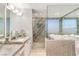 Bathroom featuring double sinks, a glass shower, and tub overlooking city views at 200 W Sahara Ave # 4101, Las Vegas, NV 89102