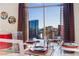 Dining area features a glass table set for a meal, with a stunning city view through a large window at 200 W Sahara Ave # 4101, Las Vegas, NV 89102