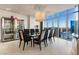 Bright dining area with a modern chandelier, glass table, and cityscape backdrop at 200 W Sahara Ave # 4101, Las Vegas, NV 89102