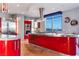 Modern kitchen features red cabinetry, stainless steel appliances, and stunning city views at 200 W Sahara Ave # 4101, Las Vegas, NV 89102