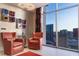 Cozy seating area with red chairs and a stunning city view through a large window at 200 W Sahara Ave # 4101, Las Vegas, NV 89102