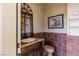 Charming powder room with designer tile, wood vanity, and wrought iron mirror at 2540 Red Arrow Dr, Las Vegas, NV 89135