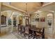 Formal dining room with a large dining table, elegant chandelier, and wine cellar access for sophisticated entertaining at 2540 Red Arrow Dr, Las Vegas, NV 89135
