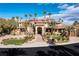 Elegant home exterior boasts a grand entrance, beautiful landscaping, and multiple palm trees at 2540 Red Arrow Dr, Las Vegas, NV 89135