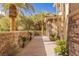 Lush landscaping with palm trees lining a stone pathway along the exterior of the home at 2540 Red Arrow Dr, Las Vegas, NV 89135