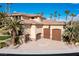 Exterior showing spacious garage with wooden doors, surrounded by palm trees and landscaping at 2540 Red Arrow Dr, Las Vegas, NV 89135