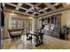Home office boasts custom built-ins, coffered ceiling, and desk with lion accents at 2540 Red Arrow Dr, Las Vegas, NV 89135