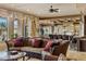 Elegant living room with plush seating, grand windows with decorative drapes, and an open layout to the kitchen at 2540 Red Arrow Dr, Las Vegas, NV 89135