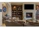 Inviting living room with a stone fireplace, custom shelving, and comfortable seating, perfect for relaxation and conversation at 2540 Red Arrow Dr, Las Vegas, NV 89135