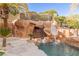 Tropical pool featuring rock features, a waterslide, and lush landscaping at 2540 Red Arrow Dr, Las Vegas, NV 89135