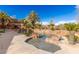 Luxury pool featuring mature palm trees, rock features, and water features at 2540 Red Arrow Dr, Las Vegas, NV 89135