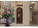 Ornate wine cellar entrance with a wrought iron door and decorative floral arrangement at 2540 Red Arrow Dr, Las Vegas, NV 89135