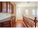 Well-lit hallway with hardwood floors, dark wood cabinets and banister at 2824 Shadows Edge Ct, Henderson, NV 89052