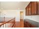 Open hallway with hardwood floors, dark wood cabinets and banister at 2824 Shadows Edge Ct, Henderson, NV 89052
