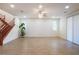 Generously sized living room boasts tile floors, recessed lighting, a ceiling fan, and a wooden staircase at 2824 Shadows Edge Ct, Henderson, NV 89052