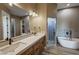 Luxurious bathroom with dual vanity, soaking tub, and a walk-in shower at 3080 S Prairie Ave, Pahrump, NV 89048