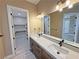 Bathroom featuring double sinks, modern lighting, and a view into the walk-in closet at 3080 S Prairie Ave, Pahrump, NV 89048
