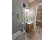 Bathroom featuring a tiled shower with glass door, vanity with a modern sink, and wood look floors at 3080 S Prairie Ave, Pahrump, NV 89048