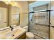 Bathroom featuring a shower with glass doors, tile surround, and sleek vanity with granite counters at 3080 S Prairie Ave, Pahrump, NV 89048