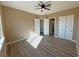 Light-filled bedroom features wood grain floors, ceiling fan, and walk-in closets for storage at 3080 S Prairie Ave, Pahrump, NV 89048