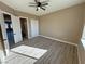 Bright bedroom with wood grain flooring, walk-in closets, and an open doorway to an ensuite bathroom at 3080 S Prairie Ave, Pahrump, NV 89048
