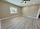 Bright bedroom with light wood-look floors and a large window at 3080 S Prairie Ave, Pahrump, NV 89048