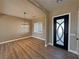 Bright dining room featuring modern light fixture, wood floors, and stylish black front door at 3080 S Prairie Ave, Pahrump, NV 89048