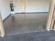 A view of epoxy garage floor with white walls and a water heater on the left wall at 3080 S Prairie Ave, Pahrump, NV 89048