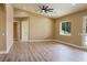 Bright living room featuring wood-look floors, modern ceiling fan, and plenty of natural light at 3080 S Prairie Ave, Pahrump, NV 89048