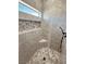 Elegant shower with hexagon floor tiles, a built-in niche, a corner seat, and a window at 3080 S Prairie Ave, Pahrump, NV 89048