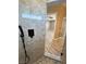 Modern shower with gray tiling, a window for natural light, and dark fixtures at 3080 S Prairie Ave, Pahrump, NV 89048