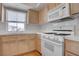 Charming kitchen featuring bright white appliances and wood cabinets under a window for natural lighting at 3604 Lisandro St # 204, Las Vegas, NV 89108