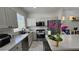 A well-appointed kitchen boasting granite countertops, stainless appliances, an island bar, and white shaker cabinetry at 3634 Surfboard Ct, Las Vegas, NV 89147