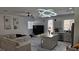 Bright living room featuring modern light fixture, large sectional sofa, and an island bar that leads to the kitchen at 3634 Surfboard Ct, Las Vegas, NV 89147