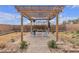 Backyard featuring a wooden pergola with seating and desert landscaping at 4211 Enchanting Sky Ave, North Las Vegas, NV 89081