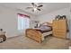 Cozy bedroom with a ceiling fan, natural light, and comfortable furnishings for relaxation and rest at 4211 Enchanting Sky Ave, North Las Vegas, NV 89081