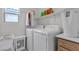 This laundry room features a washer, dryer, storage cabinet, and shelving at 4211 Enchanting Sky Ave, North Las Vegas, NV 89081