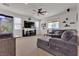 Comfortable living room with neutral carpet, ceiling fan, large windows, and a gray sectional sofa at 4211 Enchanting Sky Ave, North Las Vegas, NV 89081