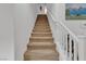 Carpeted staircase with white handrail leads to the upper level, offering a smooth transition between floors at 4211 Enchanting Sky Ave, North Las Vegas, NV 89081