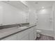 Modern bathroom featuring white cabinets, granite countertops, and shower over tub at 4244 Golden Sol St, North Las Vegas, NV 89032