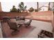 Backyard patio with seating and grill, brick retaining wall, and space for activities at 5032 Dancing Lights Ave, Las Vegas, NV 89130