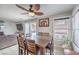 Open-concept dining area with a large wooden table, modern ceiling fan, and sliding glass doors to the backyard at 5032 Dancing Lights Ave, Las Vegas, NV 89130