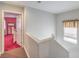 Bright hallway featuring a doorway leading to a bedroom with red carpet and a full-length mirror at 5032 Dancing Lights Ave, Las Vegas, NV 89130