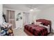 Comfortable bedroom with a unique red bed frame, ceiling fan, and plush decor at 5615 Distelrath Ave, Las Vegas, NV 89122