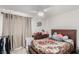 Bright bedroom featuring a ceiling fan, wood dresser, and comfortable bed with floral patterned bedding at 5615 Distelrath Ave, Las Vegas, NV 89122
