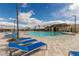 Community pool with lounge chairs and clubhouse on a sunny day at 5615 Distelrath Ave, Las Vegas, NV 89122
